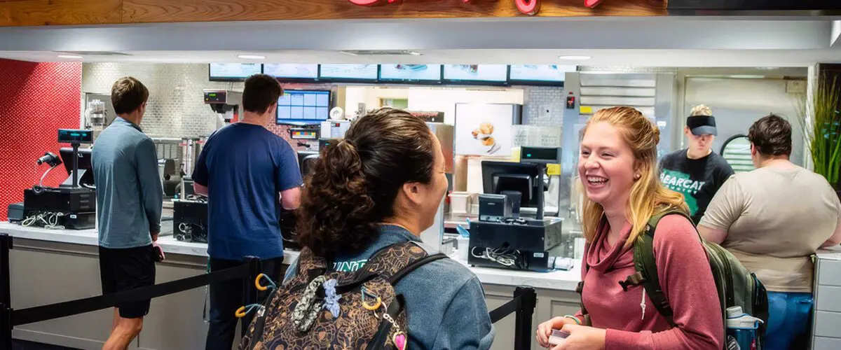 Two students conversing in front of Chick-fil-A