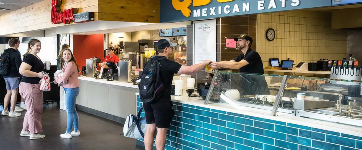 Student receiving food from Qdoba counter