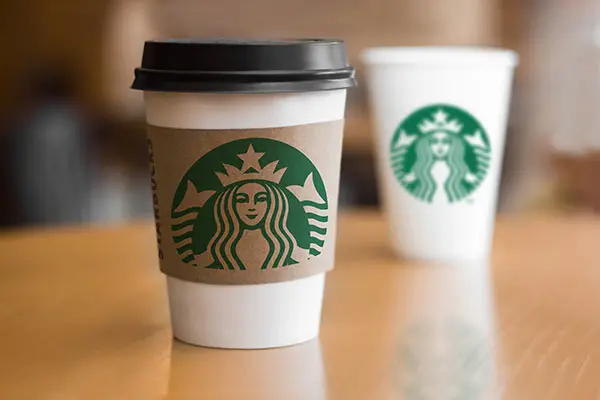Starbucks paper cups on wooden table