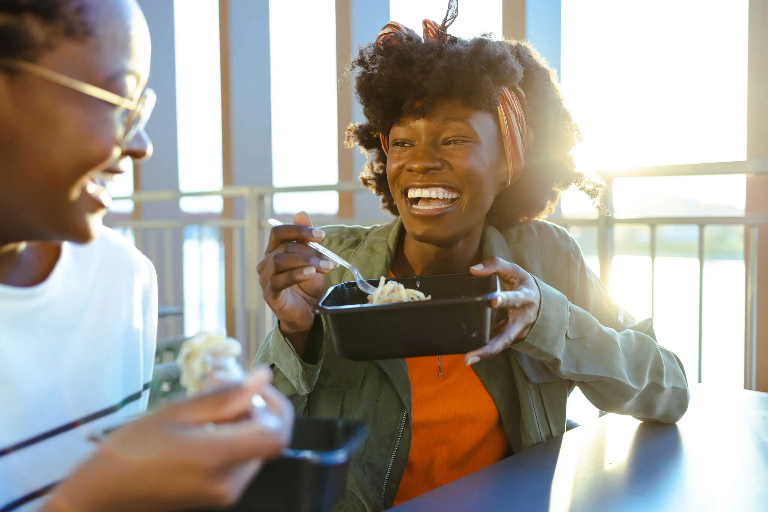 Two students sitting at a table enjoying a snack